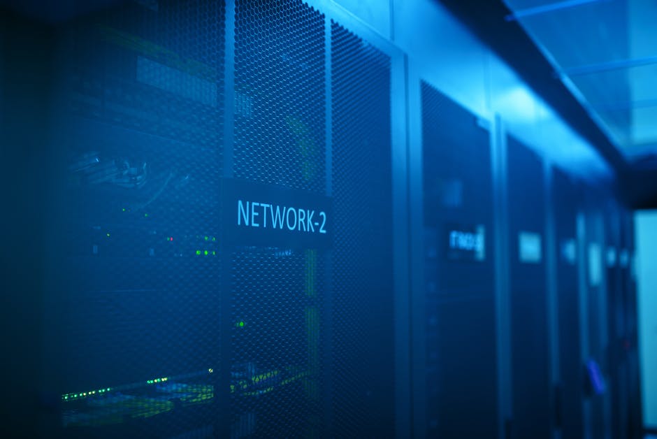 A close-up view of a network server cabinet illuminated in blue light, prominently displaying the label "NETWORK-2."