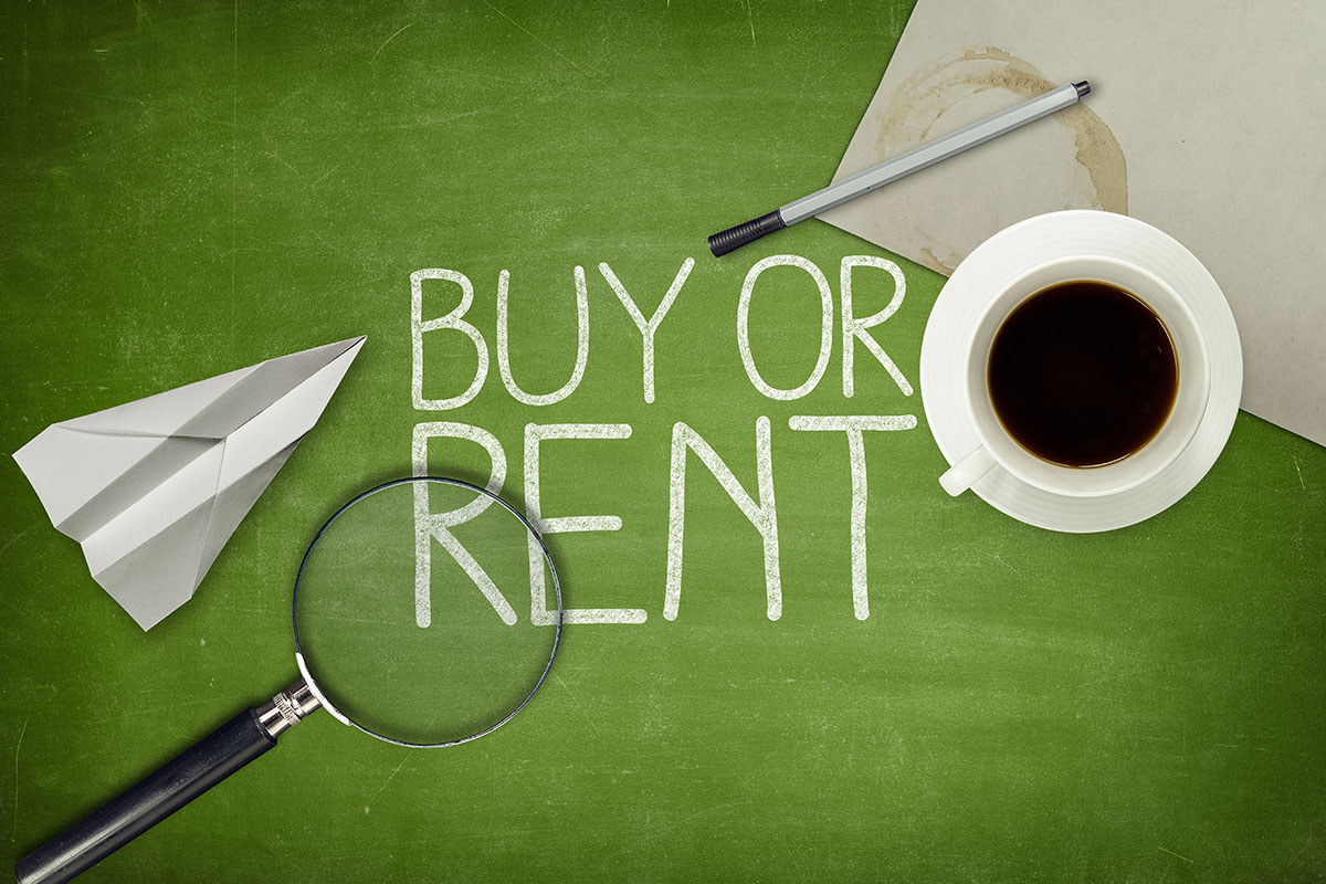 A green chalkboard with the words "BUY OR RENT" regarding Philadelphia IT equipment, written in white chalk, accompanied by a paper airplane, a magnifying glass, a cup of coffee, a pen, and a piece of paper.
