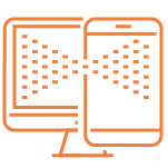 A person using a laptop and holding a smartphone, with a soft light illuminating a wooden desk.